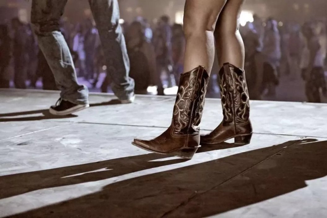 a woman wearing cowboy boots on the dance floor
