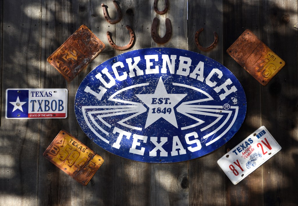 A sign and Texas automobile license plates adorn a building in Luckenbach, Texas, a popular live country music venue and tourist attraction in the Texas Hill Country. Luckenbach is an unincorporated community near Fredericksburg, Texas.