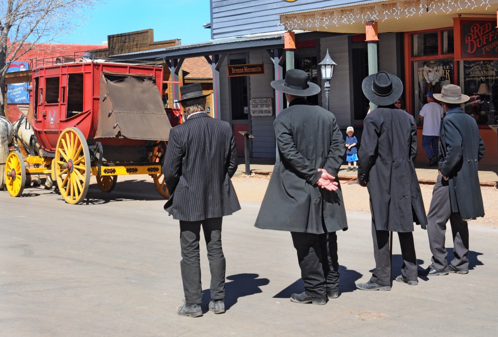 TOMBSTONE, AZ - FEBRUARY 27, 2014: Reenactors portraying Wyatt Earp, his brothers Morgan and Virgil Earp, and Doc Holliday prepare for a gunfight in historic Tombstone, Arizona. The town, featuring staged gunfights and reenactors dressed in 1800s western attire, is a popular tourist attraction. It is the site of the famed 1881 'Gunfight at the O.K. Corral' which included the Earp brothers and Holliday.