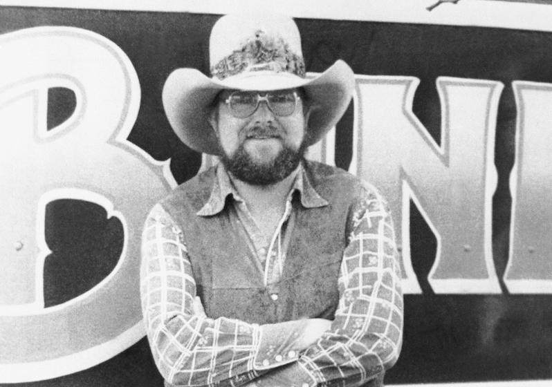Singer Charlie Daniels stands beside his tour bus at East Orange, N.J. as he gets ready for a performance at Upsala College on April 6, 1977. Daniels has moved from being a successful session guitarist in Nashville to fronting his own six-piece band. Daniels says his music isn't "country" or anything else - it's unique.