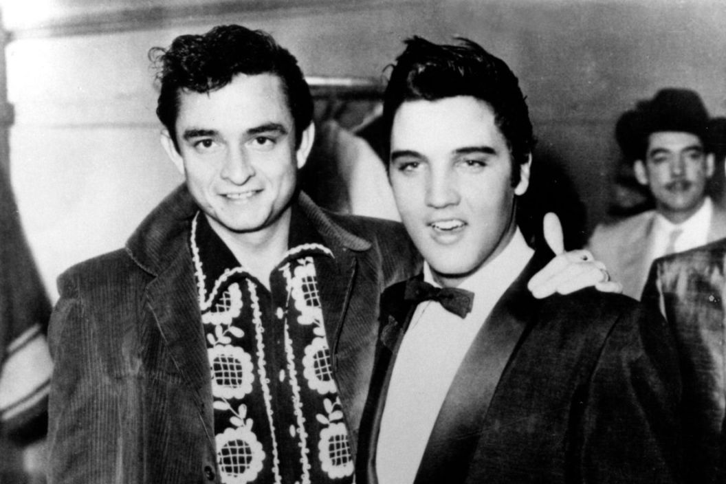 Rock and roll singers Elvis Presley and Johnny Cash pose for a portrait in December of 1957 in Memphis, Tennessee.