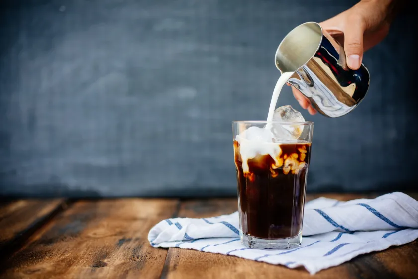 Preparing iced latte on wooden table