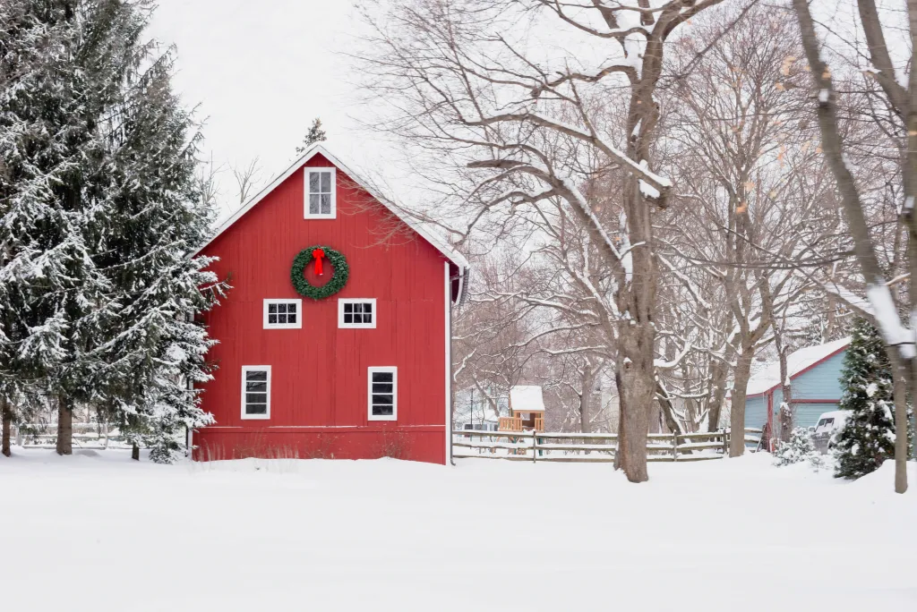 Red barn with Christmas wreath on snowy midwestern day