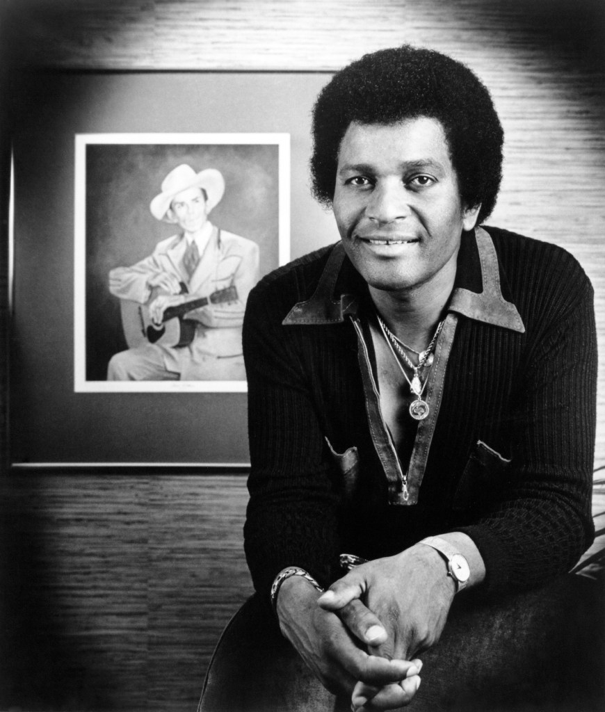  Photo of Charley Pride posing by portrait of Hank Williams.  Photo by Michael Ochs Archives/Getty Images