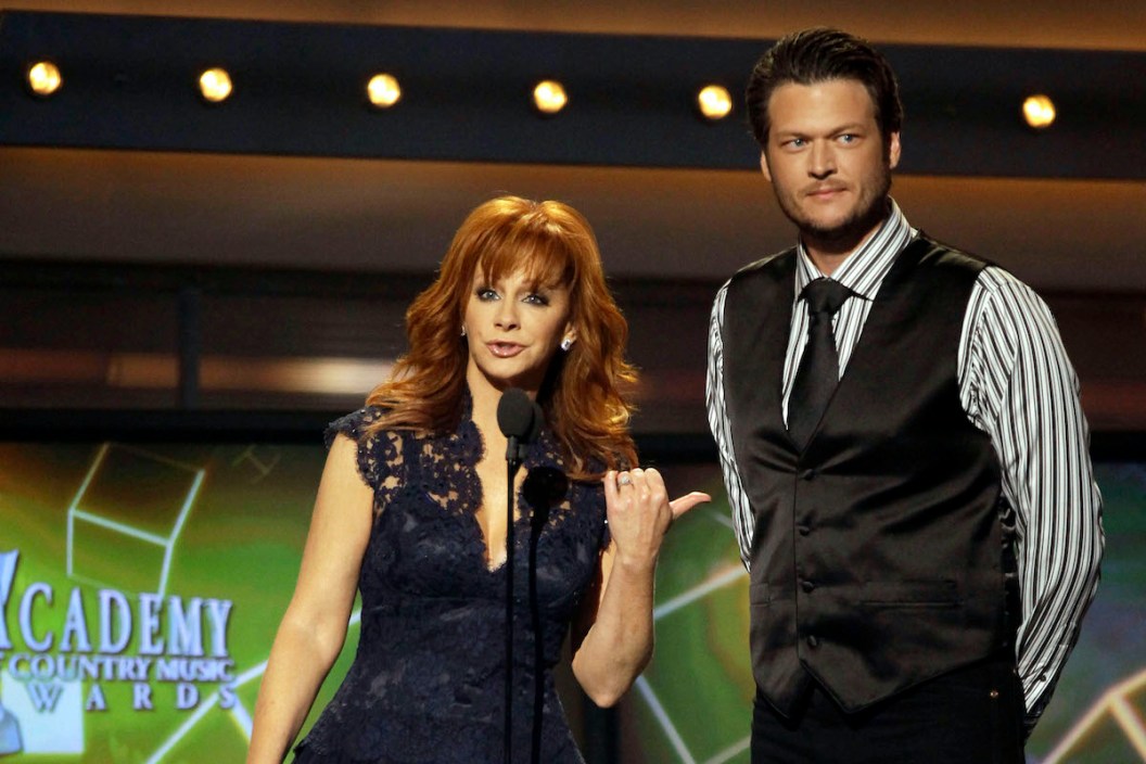 FILE - This April 3, 2011 file photo shows hosts Reba McEntire, left, and Blake Shelton onstage at the 46th Annual Academy of Country Music Awards in Las Vegas. McEntire is ending her run as host of the Academy of Country Music Awards. Sheís stepping aside after a record 14 appearances, the last two with co-host Blake Shelton, who will return on the 2013 edition of the awards show.