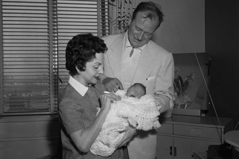 Looking like a pair of very proud parents, actor John Wayne and his leave St. Josephs Hospital here, April 6th, with their baby daughter, Aissa (CQ). The baby, born March 31st, weighed seven pounds, eight ounces.