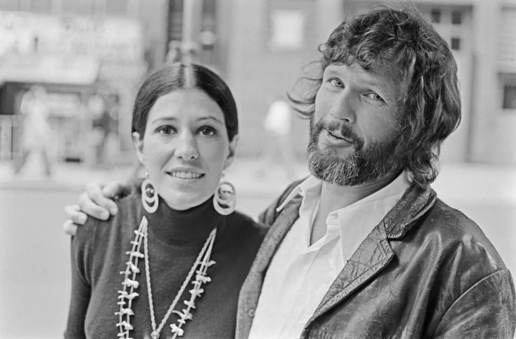 American singer Rita Coolidge, wearing a black turtleneck sweater with double circle earrings and necklaces, with her husband, American singer-songwriter and actor Kris Kristofferson, wearing a leather jacket over a white shirt, open at the collar, location unspecified, 6th November 1974. 