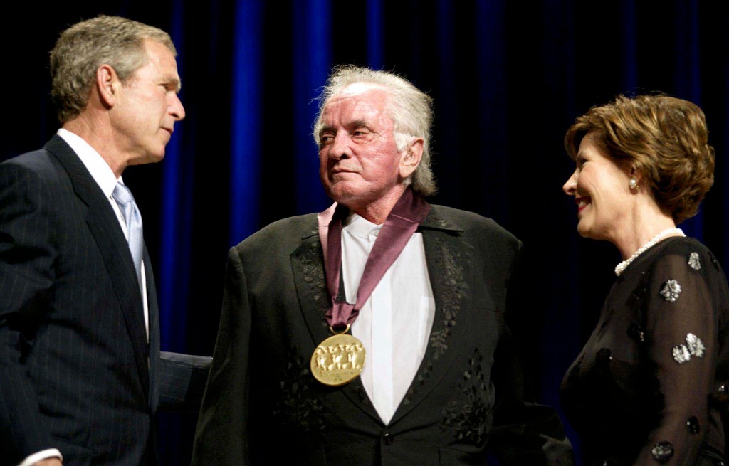 WASHINGTON, : US President George W. Bush (L) congratulates Country singer Johnny Cash (C) along with First Lady Laura Bush (R) 22 April 2002 at DAR Constitution Hall in Washington,DC, where Cash was awarded the National Medal of Arts by the National Endowment of the Arts. 