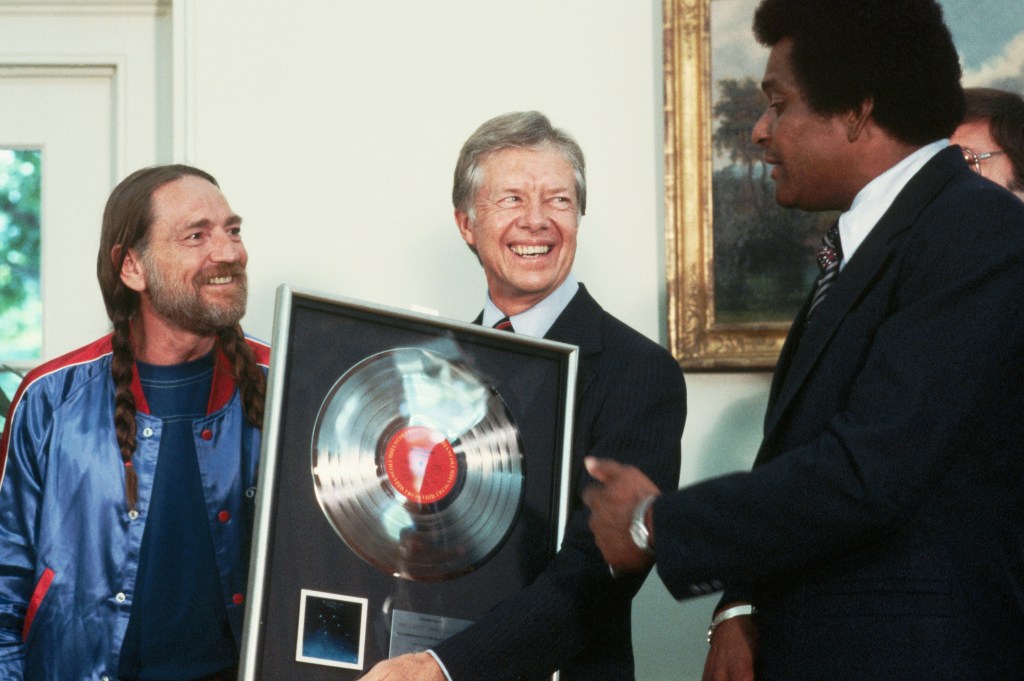 Country singers Willie Nelson and Charley Pride present a gold record to President Jimmy Carter at the Oval Office. (Photo by © Wally McNamee/CORBIS/Corbis via Getty Images)