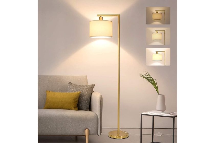 living room lamp with gold stand and base. the lamp shade is golden with a cream color