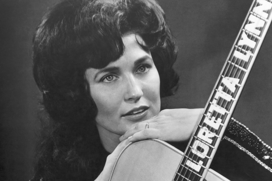Loretta Lynn poses for a portrait holding a guitar that has her name spelled down the fretboard in circa 1961 in Nashville, Tennessee.