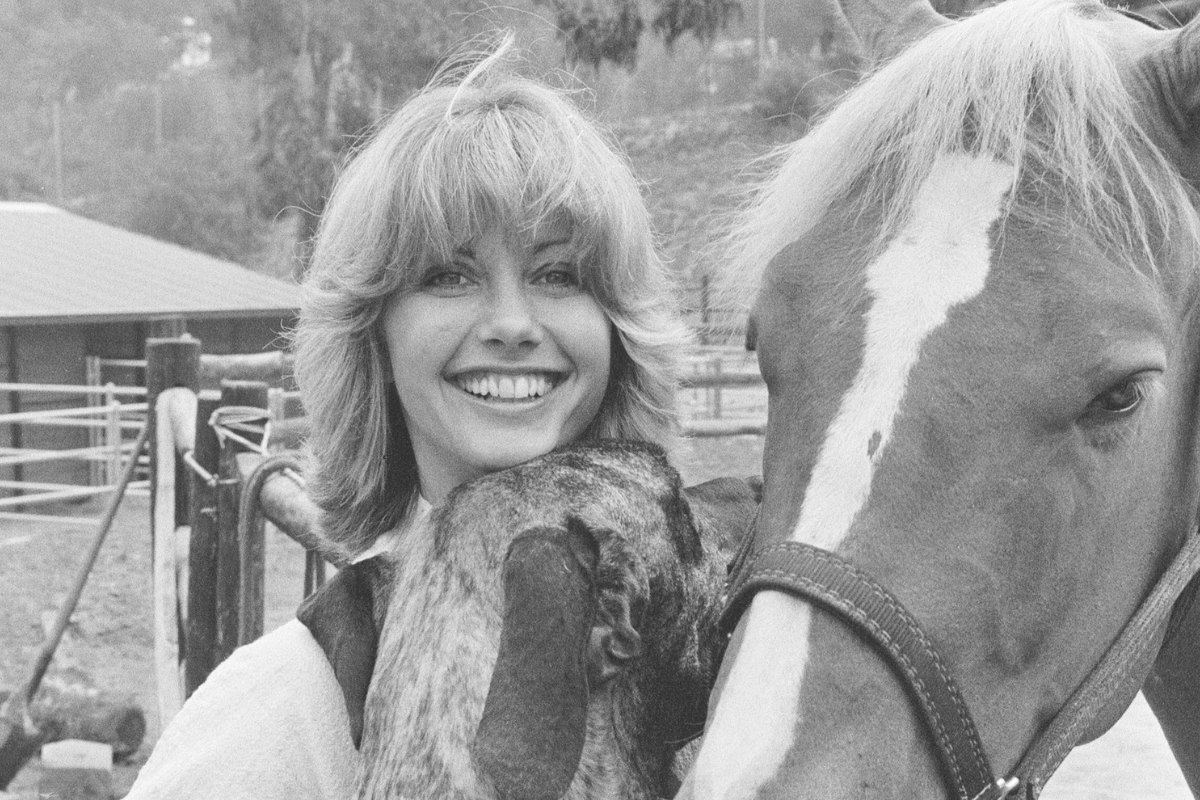 Olivia Newton John, singer and actor, pictured at home in Malibu, California, US. Pictured her with her horse and one of her dogs. Picture taken 25th July 1977. (Photo by Kent Gavin/Mirrorpix/Getty Images)