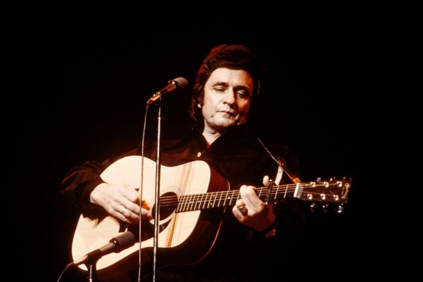 Photo of Johnny CASH and Johnny CASH; Johnny Cash performing on stage