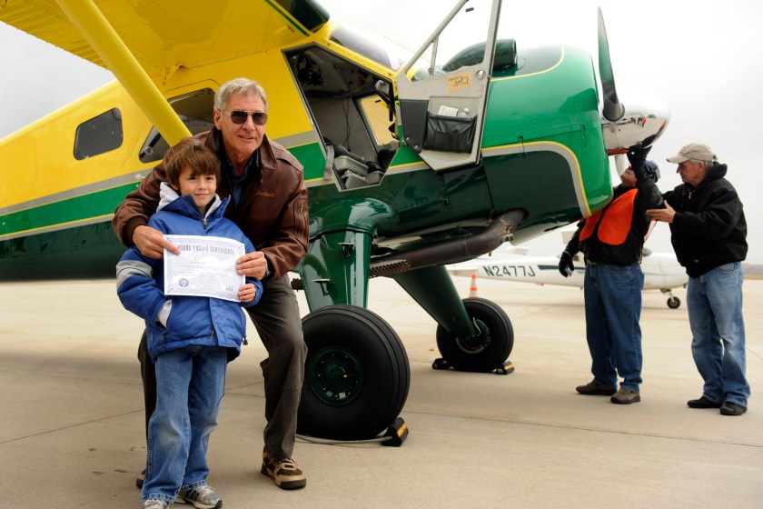 Actor Harrison Ford visits Denver and gives some kids an airplane ride from Centennial Airport. Sean Keeney, 8, of Littleton gets his photo taken with Ford after his plane ride. For Bill Husted column. Kathryn Scott Osler, The Denver Post 