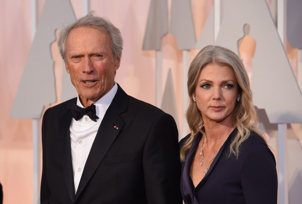 Nominee for Best Picture "American Sniper," Clint Eastwood (L) and Christina Sandera pose on the red carpet for the 87th Oscars on February 22, 2015 in Hollywood, California.