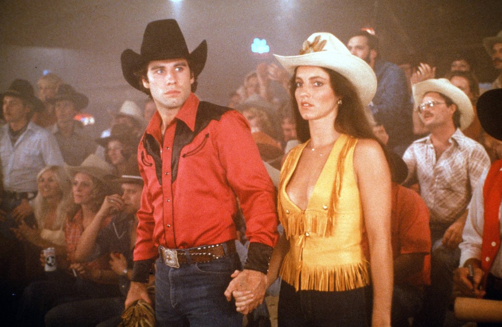 Actor John Travolta and Madolyn Smith Osborne walk in a scene of the Paramount Pictures movie  'Urban Cowboy" circa 1980. 