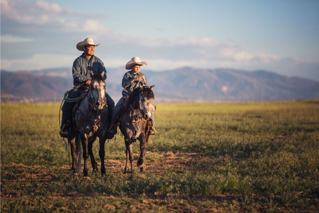 a man and son ride horses