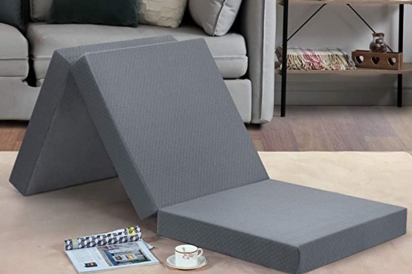 gray portable bed on living room floor showing off portability