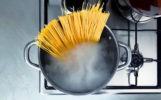 Cooking raw spaghetti in the boiling water