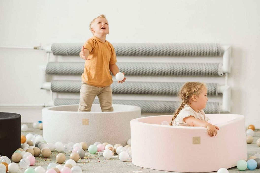 two kids playing in a ball pit for toddlers
