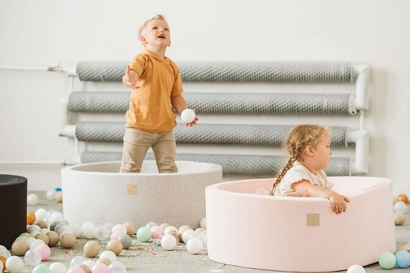 two foam ball pits for toddlers in a living room with kids playing