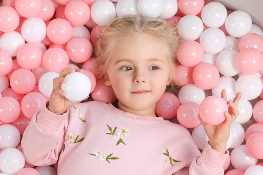 child in a pink ball pit for toddlers