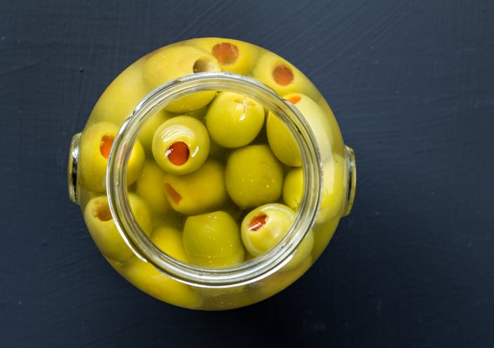 Jar of stuffed green olives in brine 
