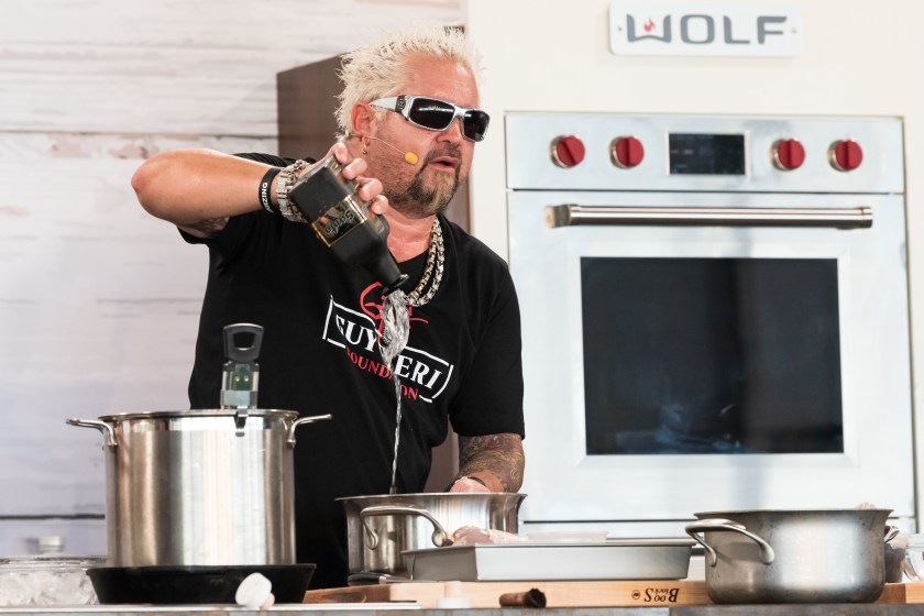 MIAMI BEACH, FLORIDA - FEBRUARY 26: Guy Fieri performs a cooking demo onstage at the Grand Tasting Village during the 2022 South Beach Wine And Food Festival on February 26, 2022 in Miami Beach, Florida.
