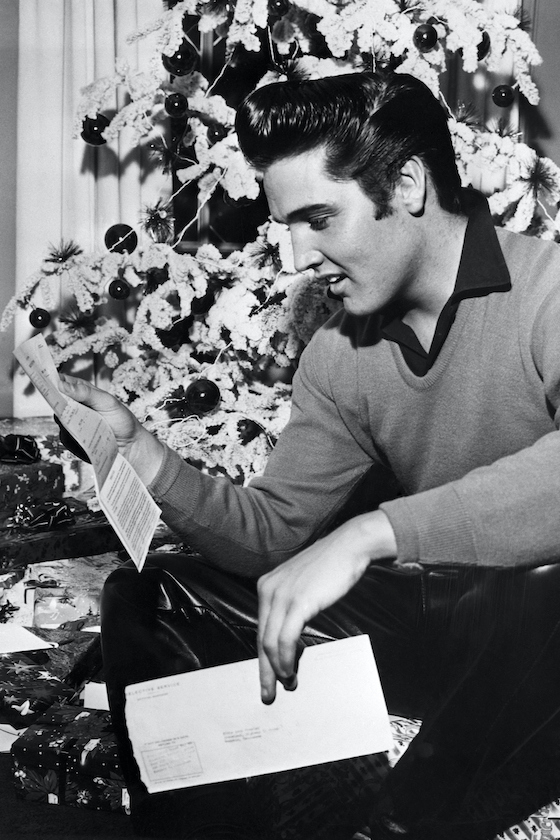 (Original Caption) 12/20/1957-Memphis, TN: Rock 'n' roll crooner Elvis Presley reads an unexpected "greeting" — a notice to report to military induction on January 20th. The idol of the teenagers is scheduled to begin making a film on the same day, however, so a studio official says that he will ask for a temporary postponement of Presley's induction. If Presley is not available for the movie, the studio and the producer will possibly lose between $300,000 and $350,000.