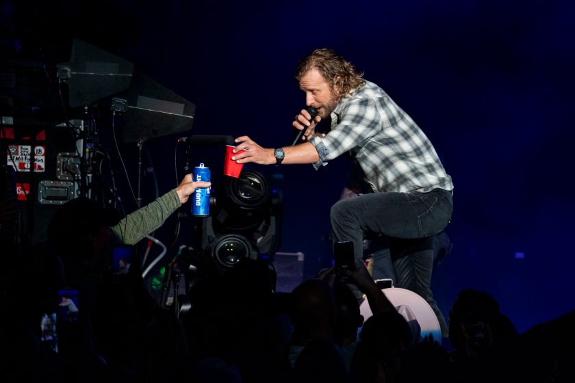 Dierks Bentley toasts an audience member during a live performance.
