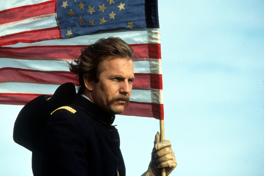 Kevin Costner holding an American flag in a scene from the film 'Dances With Wolves', 1990