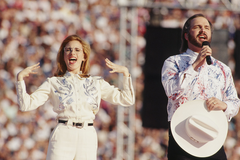 PASADENA, CA - 1993: Deaf actress Marlee Matlin joins country singer Garth Brooks in "signing" the Star Spangled Banner for the hard of hearing during the opening of the 1993 Pasadena, California, Superbowl XXVII. 