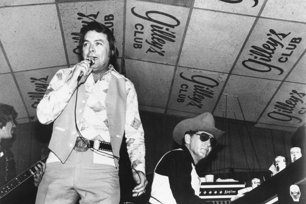 Singer and club owner Mickey Gilley performs with his cousin piano player Jerry Lee Lewis at Gilley's Club in Pasadena, Texas in circa 1975.