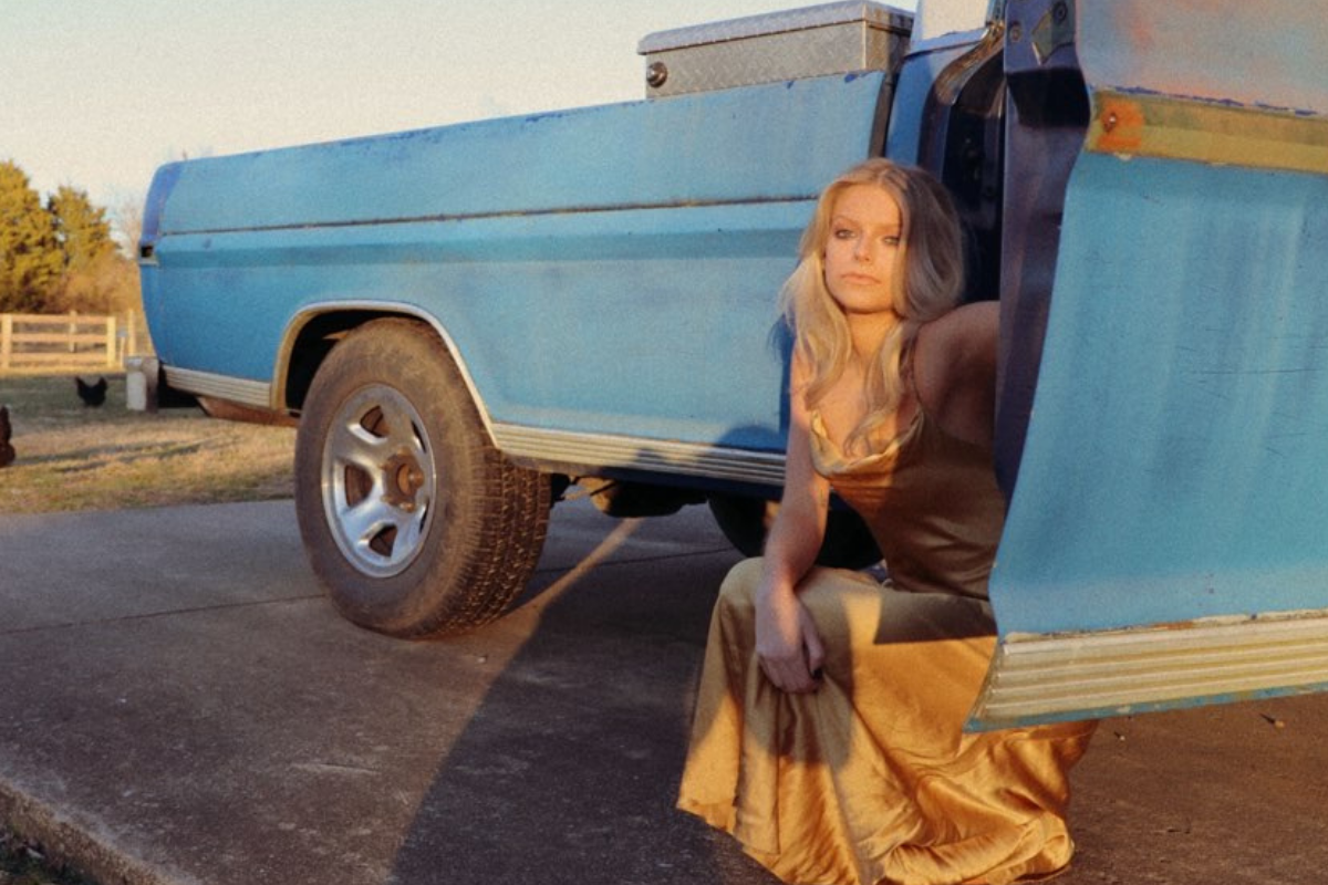 Carter Faith poses beside a pickup truck