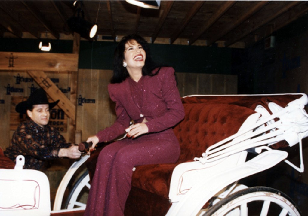 American singer Selena (born Selena Quintanilla-Perez, 1971 - 1995) rides in a carriage during a performance at the Houston Livestock Show &amp; Rodeo at the Houston Astrodome, Houston, Texas, February 26, 1995. The performance was her last before her murder the following month. (Photo by Arlene Richie/Getty Images)