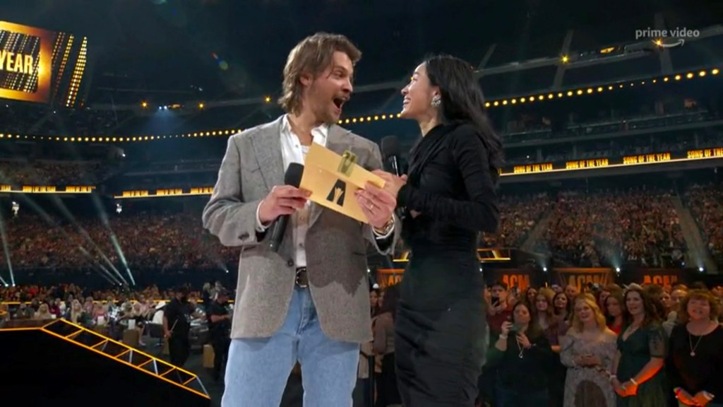 LAS VEGAS, NEVADA - MARCH 07: In this screengrab, Luke Grimes and Kelsey Asbille speak onstage during the 57th Academy of Country Music Awards at Allegiant Stadium on March 07, 2022 in Las Vegas, Nevada. (Photo by Arturo Holmes/ACMA2022/Getty Images for ACM)