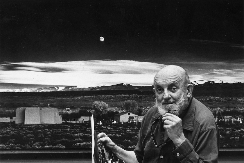 1974: Portrait of American photographer Ansel Adams (1902 - 1984) standing in front of his landscape photograph, 'Moonrise, Hernandez,' at his home in Carmel, California. He holds a photographic print in one hand, and his eyeglasses in the other. 