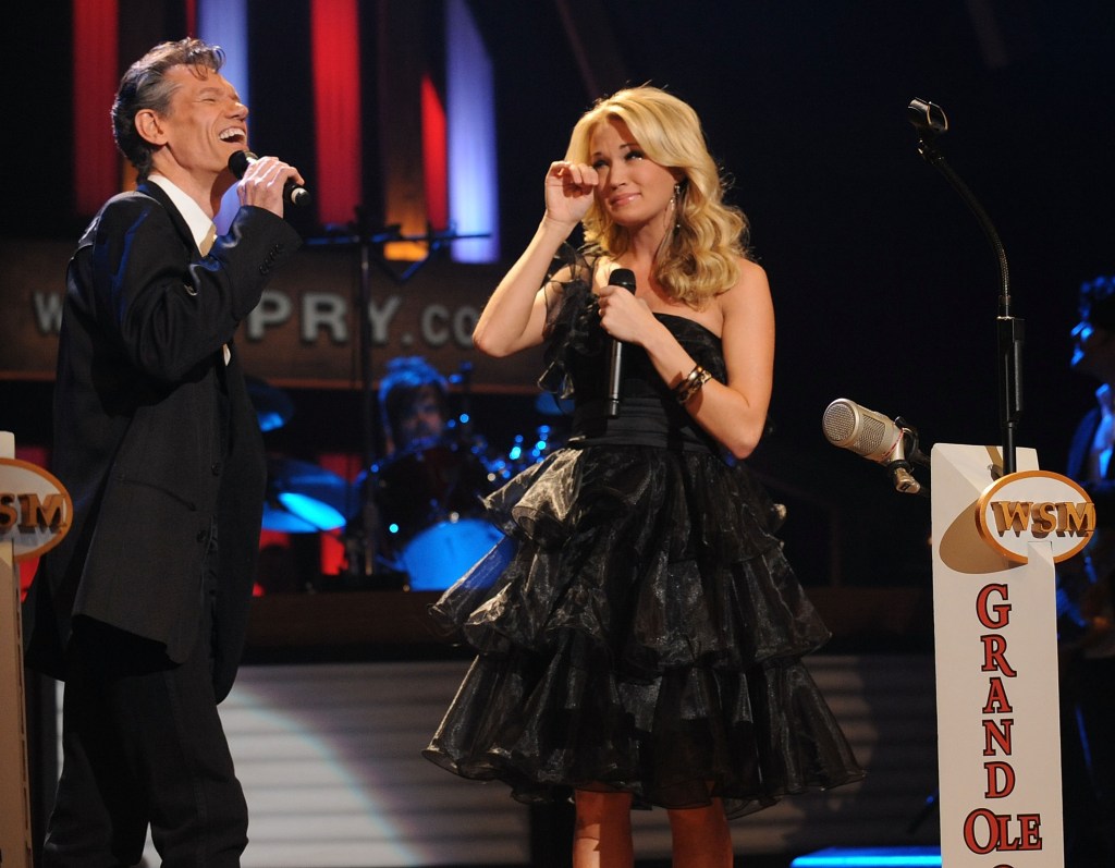 Singer/Songwriter Carrie Underwood is suprised by Opry Member and Singer/Songwriter Randy Travis when Randy invites Carrie to become a member of The Grand Ole Opry.