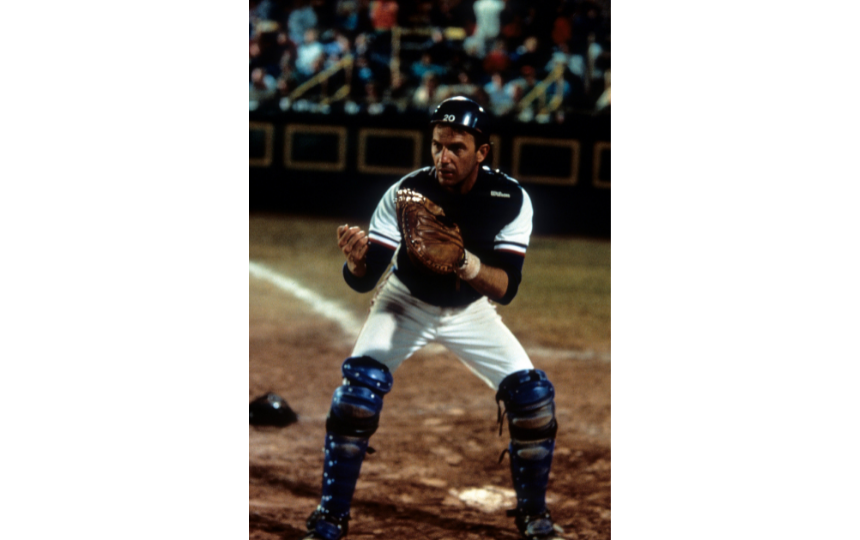 Kevin Costner playing catcher on a baseball team in a scene from the film 'Bull Durham'