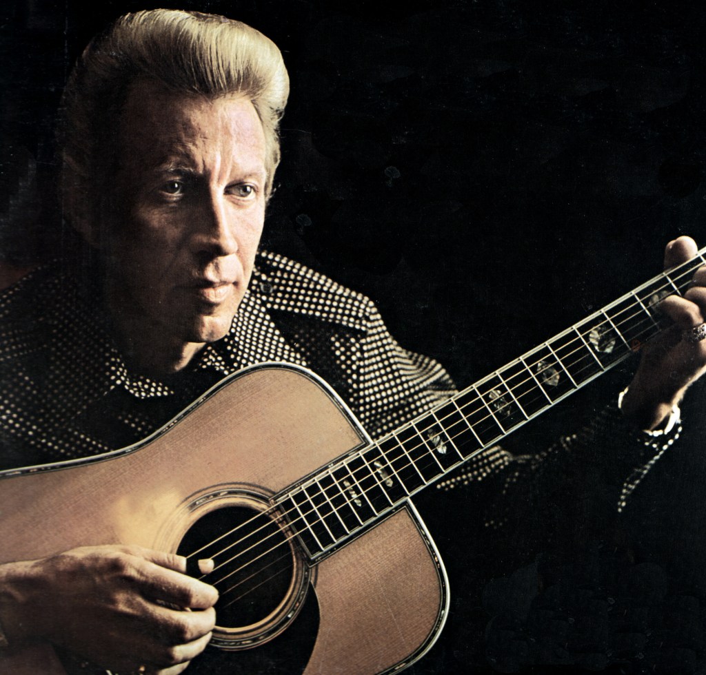 Photo of American country music singer Porter Wagoner (1927-2007) posed with acoustic guitar circa 1970.
