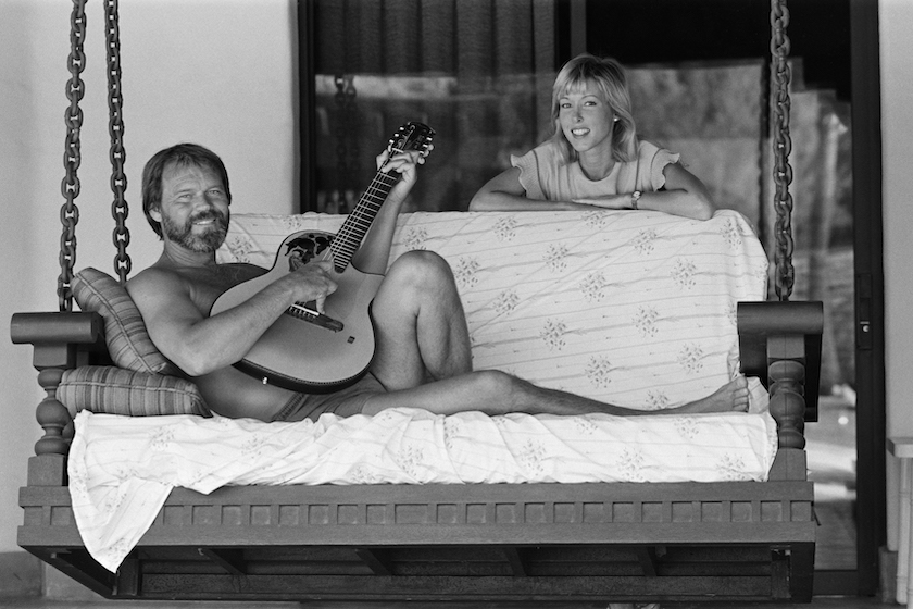 Glen Campbell and his wife to be, Kim Woollen at home in Phoenix, Arizona, USA. Glen serenades Kim, singing songs with his guitar, by the swimming pool. Campbell married to Kimberly "Kim" Woollen in 1982, 8th July 1982.