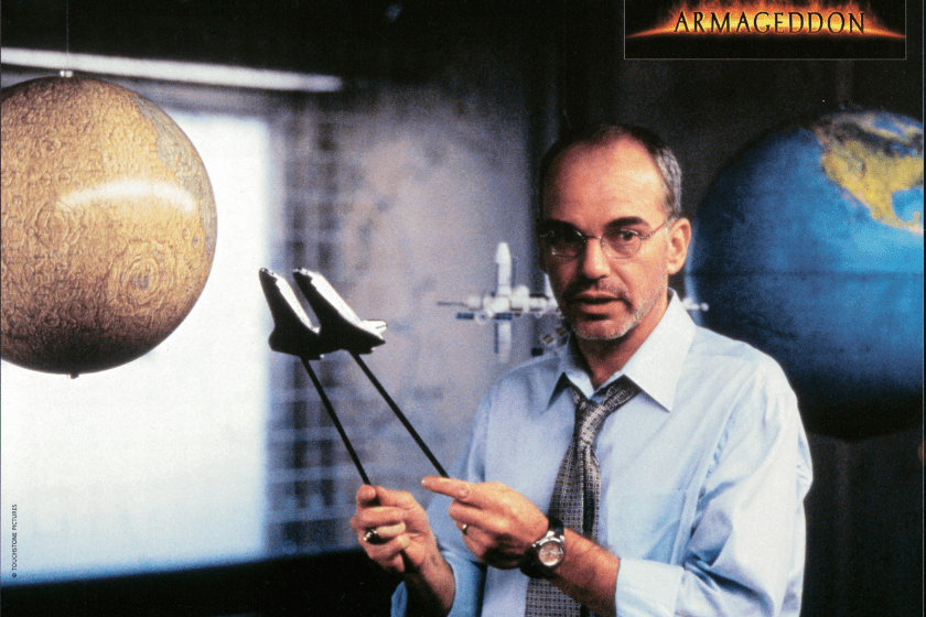 Billy Bob Thornton holding two model shuttles in a scene from the film 'Armageddon', 1998