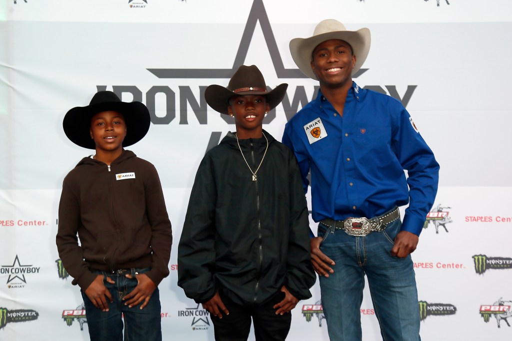 Ezekiel Mitchell poses with two Compton Cowboys kids on the red carpet, called the dirt carpet, prior to the Iron Cowboy during the Professional Bull Riders Iron Cowboy presented by Ariat on February 23, 2019, at the Staples Center, Los Angeles, CA.
