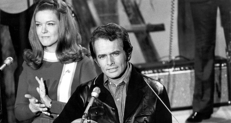 CIRCA LATE 1960s: Country musician Merle Haggard performs on stage with Bonnie Owens during a late 1960's concert.