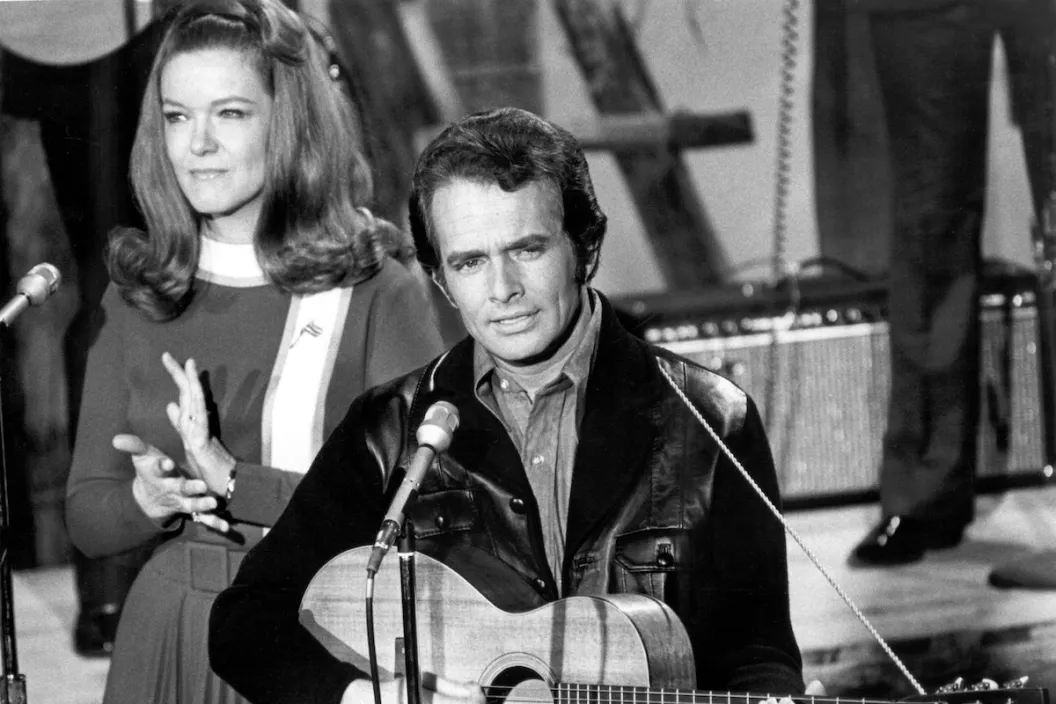 CIRCA LATE 1960s: Country musician Merle Haggard performs on stage with Bonnie Owens during a late 1960's concert.