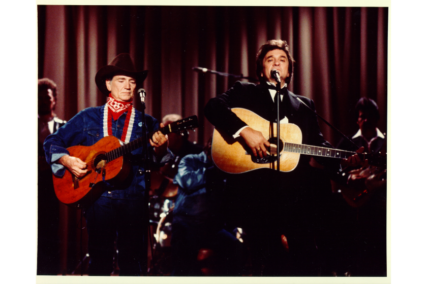 Country singers Willie Nelson and Johnny Cash perform onstage with acoustic guitars in circa 1975