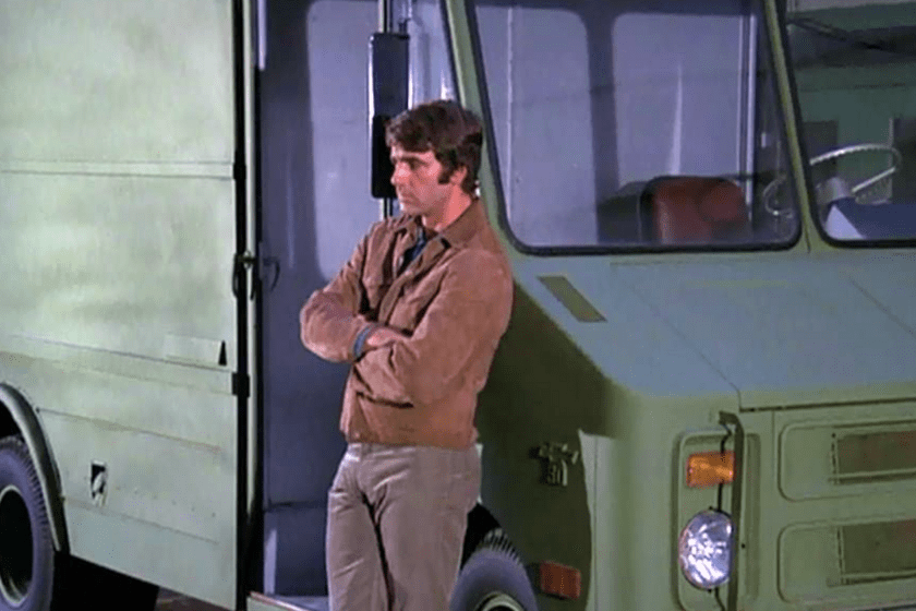 Sam Elliott leaning against a truck in a scene from the TV series 'Mission Impossible'