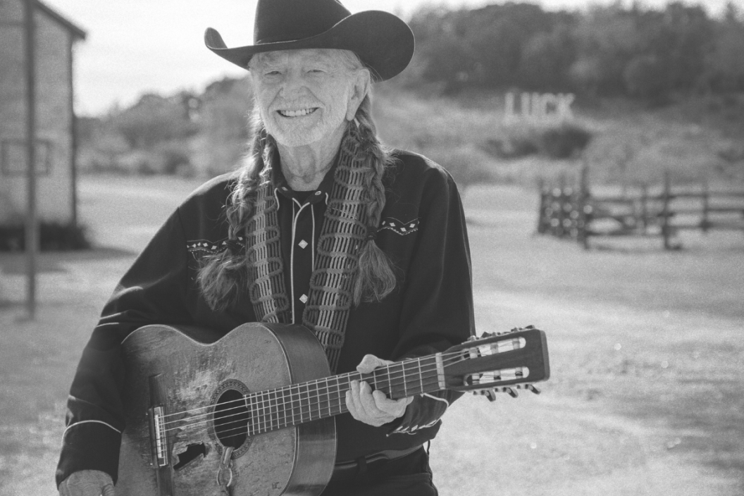 Willie Nelson poses with guitar on ranch