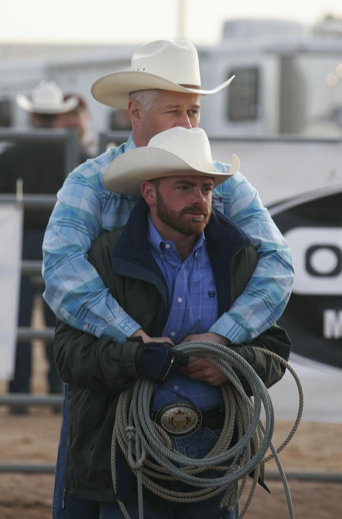 CHANDLER, United States: Brad Steele and Jay Baker (front) wait for the first competition to begin, 14 January 2006 at the 2006 Road Runner Region Rodeo in Chandler, AZ. The rodeo is part of the International Gay Rodeo Association (IGRA) annual regional circuit which will culminate at the 2006 International Gay Rodeo Association rodeo in Reno, Nevada in November. 