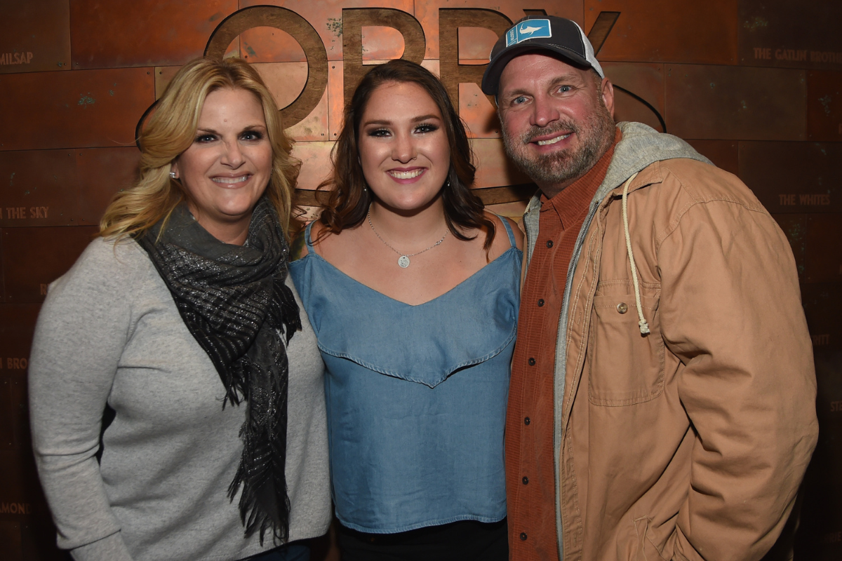 Singer/Songwriter Allie Colleen Brooks (center) Daughter of Garth Brooks and first wife Sandy Brooks poses with her stepmom Singer/Songwriter Trisha Yearwood and dad Singer/Songwriter Garth Brooks after making her Grand Ole Opry debut during Dr. Ralph Stanley Forever: A Special Tribute Concert at Grand Ole Opry House on October 19, 2017 in Nashville, Tennesse